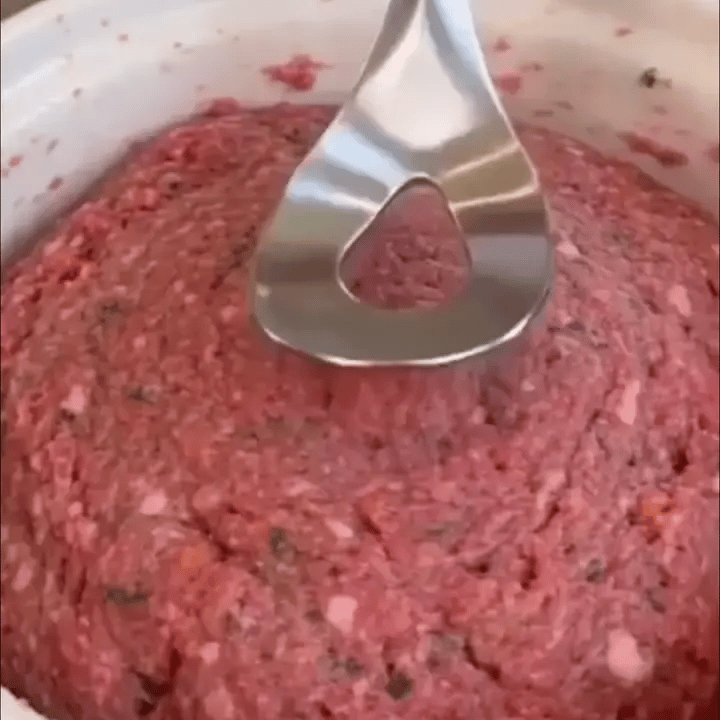 Meat mixture being scooped, pressed and released as a meatball