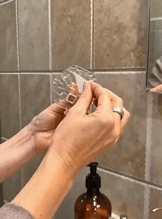 Protective backing being peeled from a clear self-adhesive wall hook