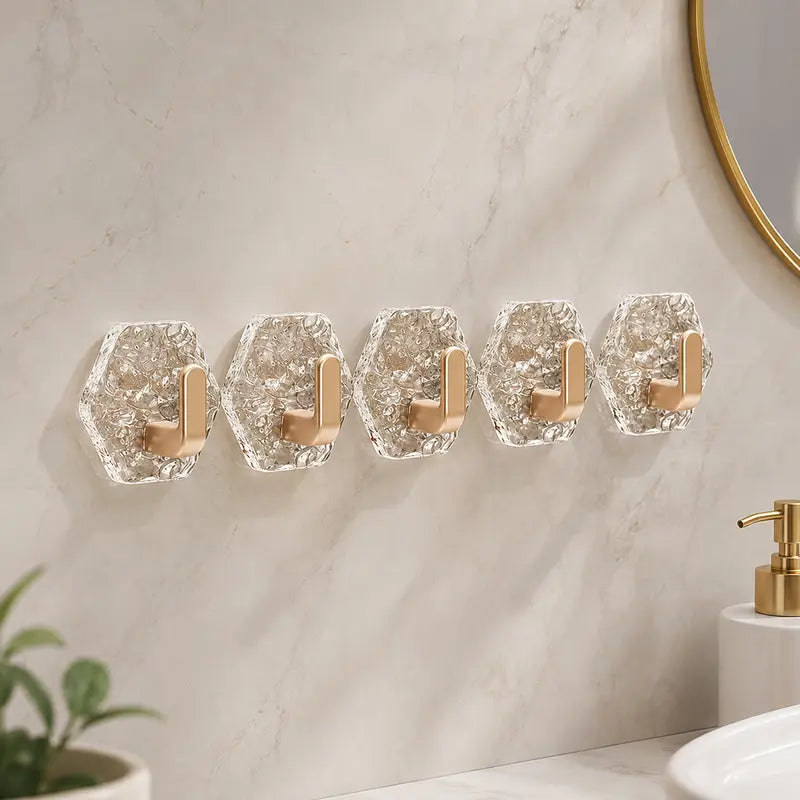 Five transparent L-shaped wall hooks arranged neatly on a bathroom wall